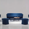 Modern blue sofa set with matching chairs in a minimalistic room.