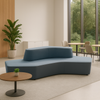 Modern blue sofa in a room with large windows, plant, and small round table.