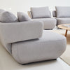 Gray sofa set in a modern living room with a white wall and wooden coffee table.