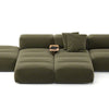 Green sectional sofa with a small table on a white background